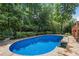 A luxurious pool is surrounded by lush greenery and a stone patio, creating a private outdoor oasis at 5602 Asheforde Ln, Marietta, GA 30068