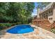 An inviting pool is framed by a stone patio and landscaped surroundings, providing a serene backyard escape at 5602 Asheforde Ln, Marietta, GA 30068