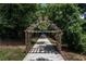 Inviting riverwalk entrance with a wooden pergola, leading to a scenic path at 5602 Asheforde Ln, Marietta, GA 30068