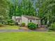 A quaint home surrounded by lush greenery showcases a peaceful, wooded lot at 766 Lost Creek Cir, Stone Mountain, GA 30088