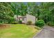 Charming home with a lush lawn and mature trees surrounding the property at 766 Lost Creek Cir, Stone Mountain, GA 30088