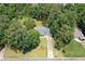 An aerial view showcasing the house nestled among lush greenery, with a long driveway leading to the property at 130 Sunnybrook Ln, Woodstock, GA 30188