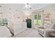 Cozy Bedroom features a crib, chair, and window with backyard views at 130 Sunnybrook Ln, Woodstock, GA 30188