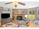 Cozy living room with a stone fireplace, ceiling fan, and comfortable seating at 130 Sunnybrook Ln, Woodstock, GA 30188