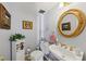 Charming powder room featuring a round mirror, classic fixtures, and decorative accents at 1487 W Bend Creek Ct, Atlanta, GA 30338