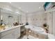 Elegant bathroom with a soaking tub, vanity, and tiled walls at 1487 W Bend Creek Ct, Atlanta, GA 30338