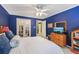 Blue bedroom with closet access, featuring a cozy bed and dresser with TV for relaxation at 1487 W Bend Creek Ct, Atlanta, GA 30338