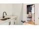 Bathroom with sink and vanity, leading into a gray bedroom with an area rug at 3233 Osborne Ne Rd, Brookhaven, GA 30319