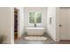 Bright bathroom with soaking tub next to a window and view into a walk in closet at 3233 Osborne Ne Rd, Brookhaven, GA 30319
