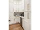 Well-organized pantry featuring white cabinets with brass hardware and modern appliances to enhance storage and convenience at 3233 Osborne Ne Rd, Brookhaven, GA 30319