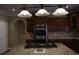 Kitchen boasts dark wood cabinetry, stainless steel appliances, and a granite countertop island at 4663 Mossey Dr, Lithonia, GA 30038