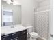 Modern bathroom with a white vanity, gray tile, and shower/bath combination with a patterned curtain at 318 Lantana Ln, Woodstock, GA 30188