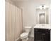 Bathroom with black vanity, white sink and bath/shower with tan and white curtain at 318 Lantana Ln, Woodstock, GA 30188