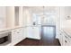 Open-concept kitchen with white cabinets, granite countertops, stainless steel appliances, and hardwood floors at 318 Lantana Ln, Woodstock, GA 30188