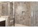Detailed view of the stone tile shower with built-in bench and glass door enclosure at 318 Lantana Ln, Woodstock, GA 30188