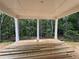 A covered porch in the back of the home overlooking a wooded backyard at 5361 Tuscany Dr, Douglasville, GA 30135