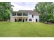 Expansive, lush backyard with a white two-story home featuring a stunning glass enclosed porch at 6095 Fords Nw Rd, Acworth, GA 30101