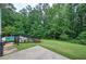 Landscaped backyard with a pool, patio, trees, and green lawn at 6095 Fords Nw Rd, Acworth, GA 30101