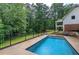In-ground pool surrounded by a concrete patio, steps, landscaping, and a fenced backyard at 6095 Fords Nw Rd, Acworth, GA 30101