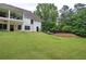 Lush green backyard with a view of the house and backyard pool in a wooded surrounding at 6095 Fords Nw Rd, Acworth, GA 30101