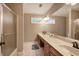 Bathroom with double sink vanity with storage, shower with glass door, mirrors, and tiled flooring at 6095 Fords Nw Rd, Acworth, GA 30101