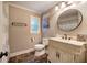 Elegant bathroom features a round mirror, and a custom vanity with marble-like flooring at 6095 Fords Nw Rd, Acworth, GA 30101