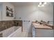Bathroom featuring a large soaking tub, a walk-in shower with neutral tile, and custom lighting at 6095 Fords Nw Rd, Acworth, GA 30101