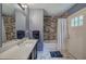 Stylish bathroom with stone-look walls, single sink vanity, and shower/tub combo at 6095 Fords Nw Rd, Acworth, GA 30101