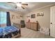 Bedroom with carpet flooring, window with curtains, dresser, bed, chair, and ceiling fan for comfort at 6095 Fords Nw Rd, Acworth, GA 30101