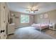 Carpeted bedroom with a white metal bed frame, windows, ceiling fan, and dresser offers a cozy retreat at 6095 Fords Nw Rd, Acworth, GA 30101