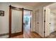 Hallway features a sliding barn door, hardwood floors, and access to the bathroom at 6095 Fords Nw Rd, Acworth, GA 30101
