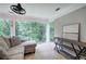 Inviting sunroom with large windows, neutral furniture, fan, and backyard views at 6095 Fords Nw Rd, Acworth, GA 30101