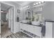 Double vanity bathroom featuring granite counters, framed mirrors, decorative lighting, and wood look floors at 859 Scales Rd, Suwanee, GA 30024