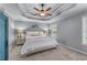 Comfortable bedroom with a decorative tray ceiling, a ceiling fan, soft carpeting, and a queen bed at 859 Scales Rd, Suwanee, GA 30024