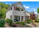 Charming two-story home with a covered porch, stone accents, and colorful landscaping at 859 Scales Rd, Suwanee, GA 30024