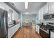 Bright kitchen boasts stainless appliances, white cabinets, granite counters, and eat-in breakfast nook at 859 Scales Rd, Suwanee, GA 30024