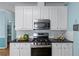 Modern kitchen featuring white cabinets, stainless steel appliances, and sleek black countertops at 859 Scales Rd, Suwanee, GA 30024