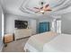 Main bedroom with tray ceilings, ceiling fan, neutral carpeting, and abundant storage space at 859 Scales Rd, Suwanee, GA 30024