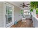 Inviting covered porch with rocking chairs, ceiling fan, and access to the backyard at 859 Scales Rd, Suwanee, GA 30024