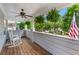 Inviting covered porch with rocking chairs, ceiling fan, and views of the landscaped yard at 859 Scales Rd, Suwanee, GA 30024