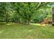 Backyard with mature trees, a large lawn area, and a wooden deck at 115 Bennett Farms Dr, Acworth, GA 30102