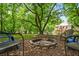 A spacious backyard with firepit is surrounded by mature trees, perfect for outdoor enjoyment at 115 Bennett Farms Dr, Acworth, GA 30102