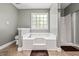 Bathroom with bathtub, glass shower, window, and neutral color scheme at 115 Bennett Farms Dr, Acworth, GA 30102