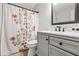 Bathroom features a shower-tub combination, a white vanity with framed mirror and a floral shower curtain at 115 Bennett Farms Dr, Acworth, GA 30102