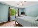Inviting bedroom with hardwood floors, a ceiling fan, and a large window with a wooded view at 115 Bennett Farms Dr, Acworth, GA 30102