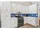 Bright kitchen featuring white cabinetry, modern appliances, and blue backsplash at 115 Bennett Farms Dr, Acworth, GA 30102