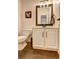 Stylish half bath with wood-look tile flooring and a modern vanity with sleek fixtures at 2230 Laurel Lake Dr, Suwanee, GA 30024