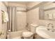 Bathroom with tiled walls, a tub with a shower, a toilet, a towel bar, and a sink at 2573 Mistletoe Ln, Snellville, GA 30039