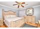 Bedroom with a large bed, hardwood floors, ceiling fan, and a dresser with a decorative mirror at 2573 Mistletoe Ln, Snellville, GA 30039