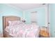 Bright bedroom featuring light blue walls, hardwood floors, a large window and a cozy bed with patterned bedding at 2573 Mistletoe Ln, Snellville, GA 30039